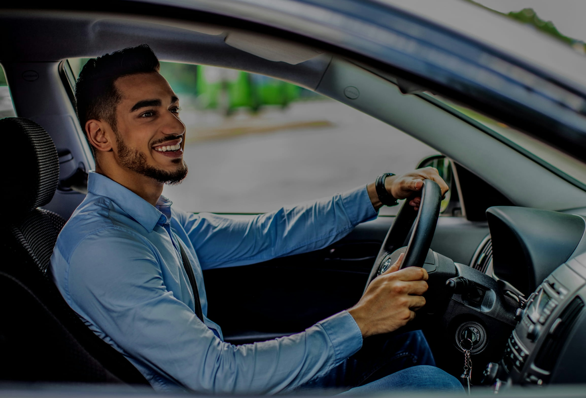 A smiling businessman driving a car