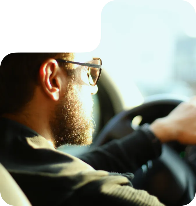 A bearded man driving a car